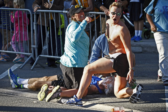 David James, 32, of Fort Myers and another yell for medial help as fallen Greg Wolpert, 59, of Naples suffers from cardiac arrest during the Naples Daily News Half Marathon Sunday, Jan. 18, 2015 in downtown Naples, Fla. Just under 2,400 people registered to race. Kenyans Cleophas Ngetich and Zipporah Chebeat were the male and female winners of the 2015 Naples Daily News Half Marathon on Sunday. First responders resuscitated Wolpert on scene saving his life.(Corey Perrine/Staff)